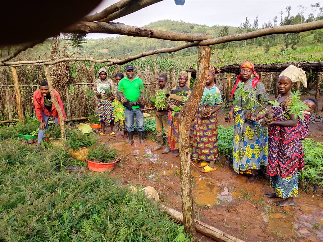 Green for Life Rwanda community members holding seedlings during field training